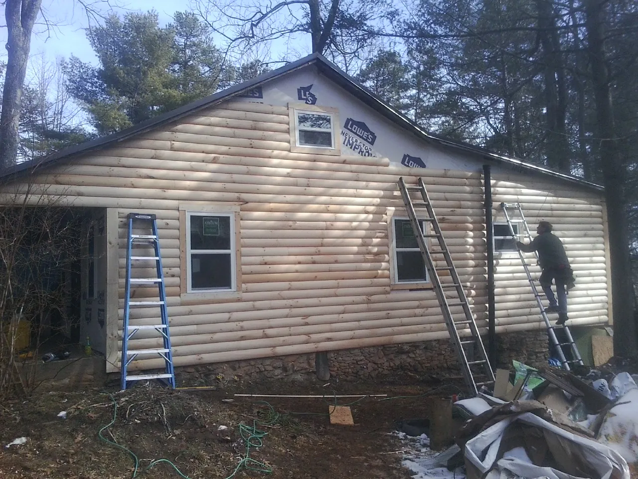 Ladders set against fresh log siding during an exterior remodel in Franklin