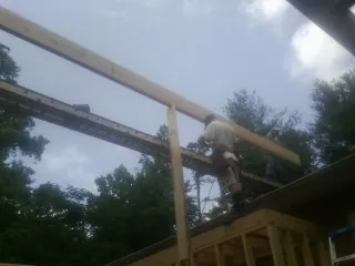 Carpenter setting a ridge beam over a new addition frame — Ice Dam Removal by Roofing Brothers in Franklin